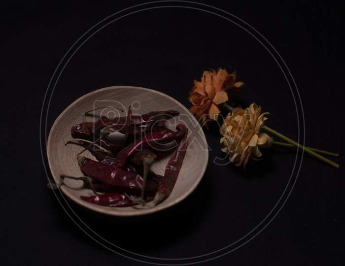 Different Whole Spices In A Wooden Bowl Decorated With Dried Flowers In A Dark Copy Space Background.