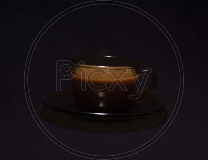 Hot Infused Tea In A Transparent Glass Cup And Soccer Kept In Black Copy Space Background. Indian Beverages And Food Photography.