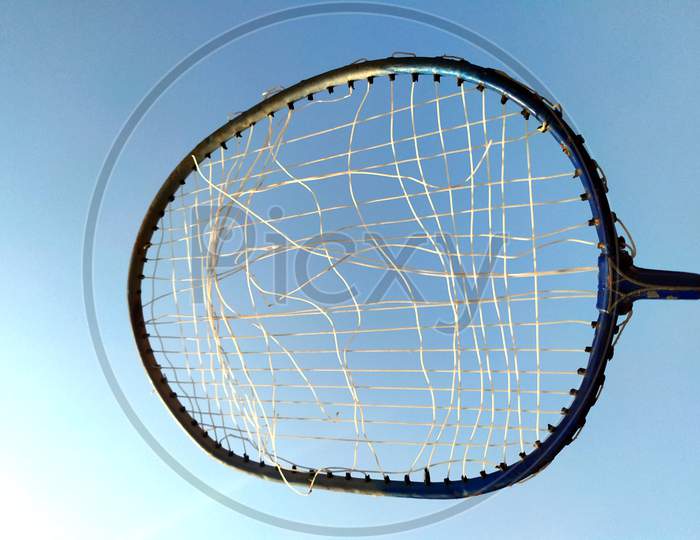 a broken wire racket whit light blue background