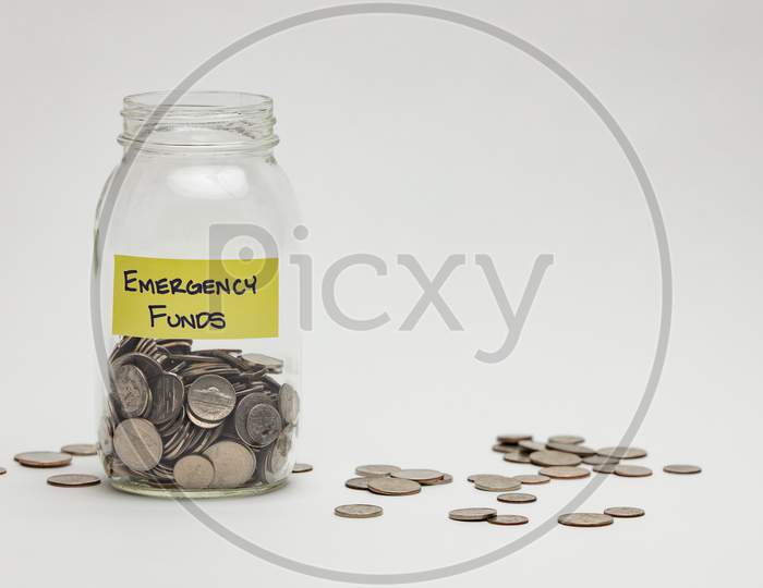 Emergency Funds Savings With Coins in a Glass Jar  Over an isolated White Background 