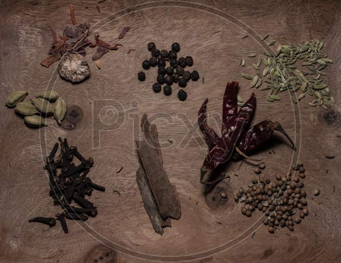 Different Whole Spices In A Wooden Background.