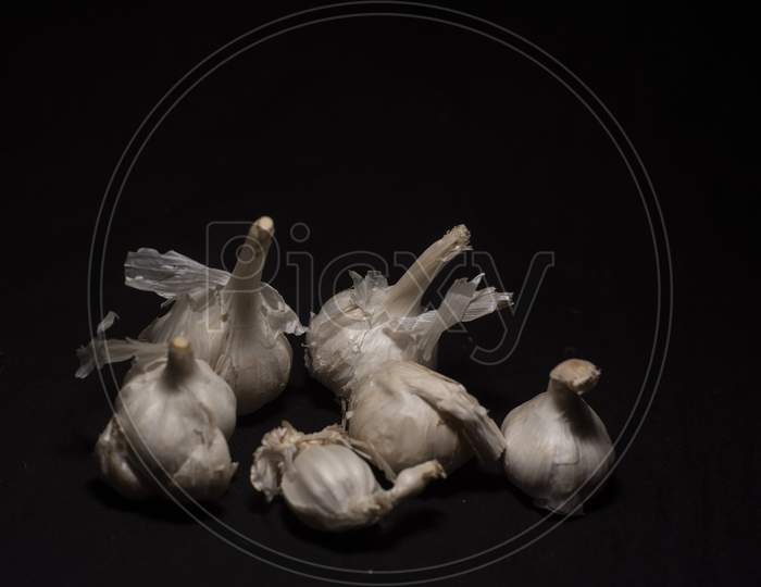 A Collection Of Garlic In Dark Copy Space Background. Food And Product Photography
