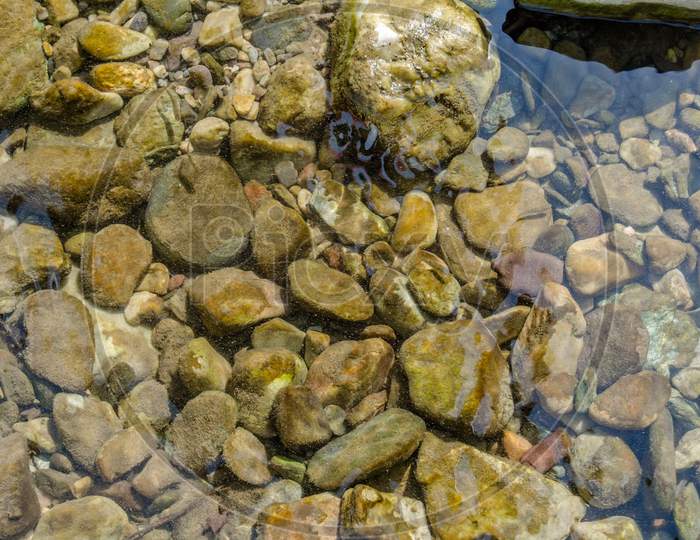 Stones under crystal clear water of  Ganga River at Rishikesh