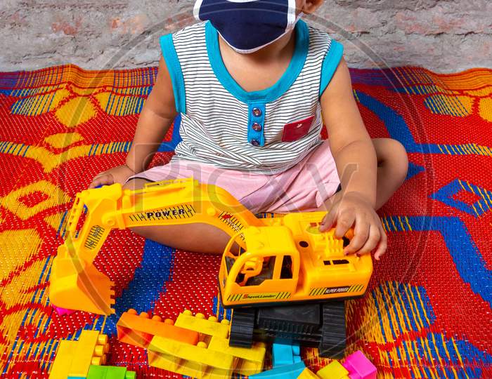 Bangladesh – April 15, 2020: A One-Year-Old Child Is Playing With Her Colorful Toys After Wearing A Face Mask For Safety Reasons At Dhaka, Bangladesh.