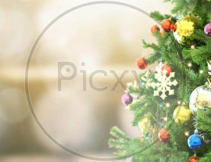 Decorated Christmas Tree On  Blurred Background. Pine Cone And Snow Flakes