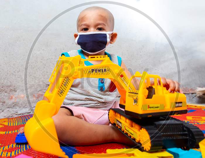 Bangladesh – April 15, 2020: A One-Year-Old Child Is Playing With Her Colorful Toys After Wearing A Face Mask For Safety Reasons At Dhaka, Bangladesh.
