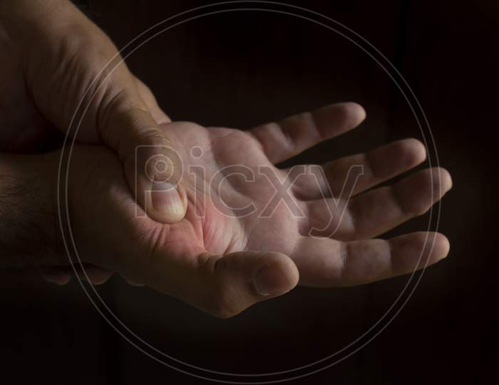 A Man'S Hand Squeezing The Metacarpus Of The Thumb. Joint Pain In The Right Hand. Black Background. Free Space To Write.