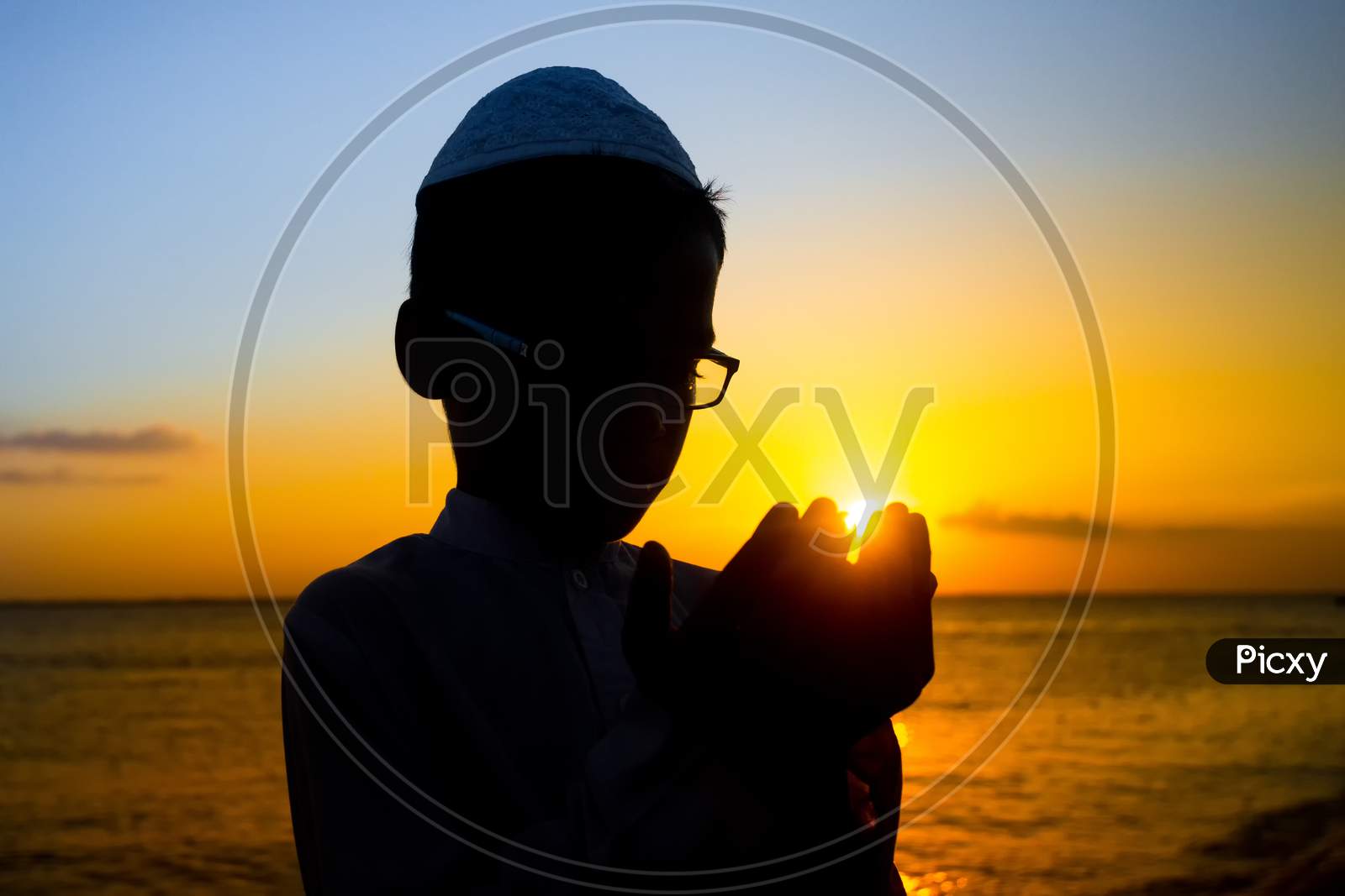 Bangladesh – June 22, 2019: A Muslim Boy Is Praying By The Riverside At Sunset In The Evening Time At Chandpur, Bangladesh.