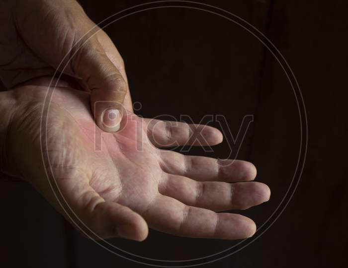 A Man'S Hand Squeezing The Joint Of The Fifth Finger. Joint Pain In The Right Hand. Black Background. Free Space To Write.