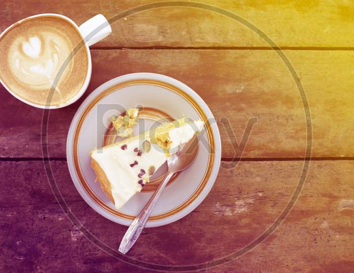 Slice Of Homemade Cake With Cup Of Latte On Wooden table