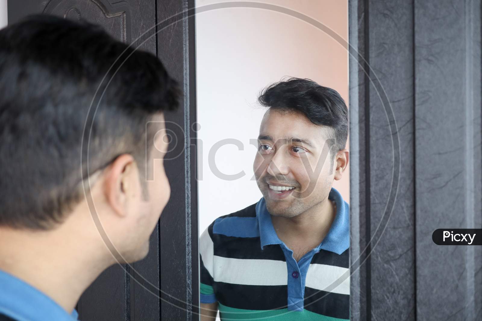 A Man Looking At His Reflection In Mirror Smiling In Happy Mood
