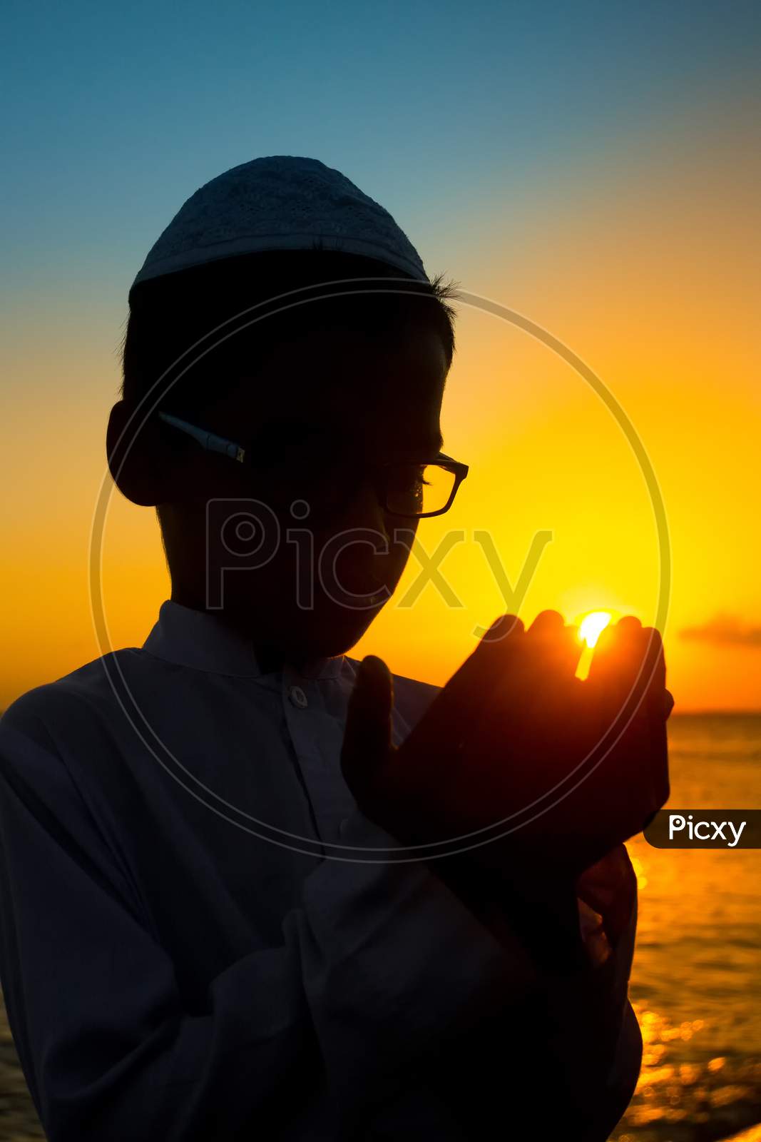 Bangladesh – June 22, 2019: A Muslim Boy Is Praying By The Riverside At Sunset In The Evening Time At Chandpur, Bangladesh.