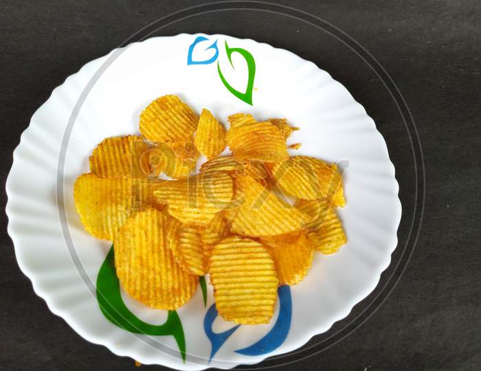 Tasty chips on plate.