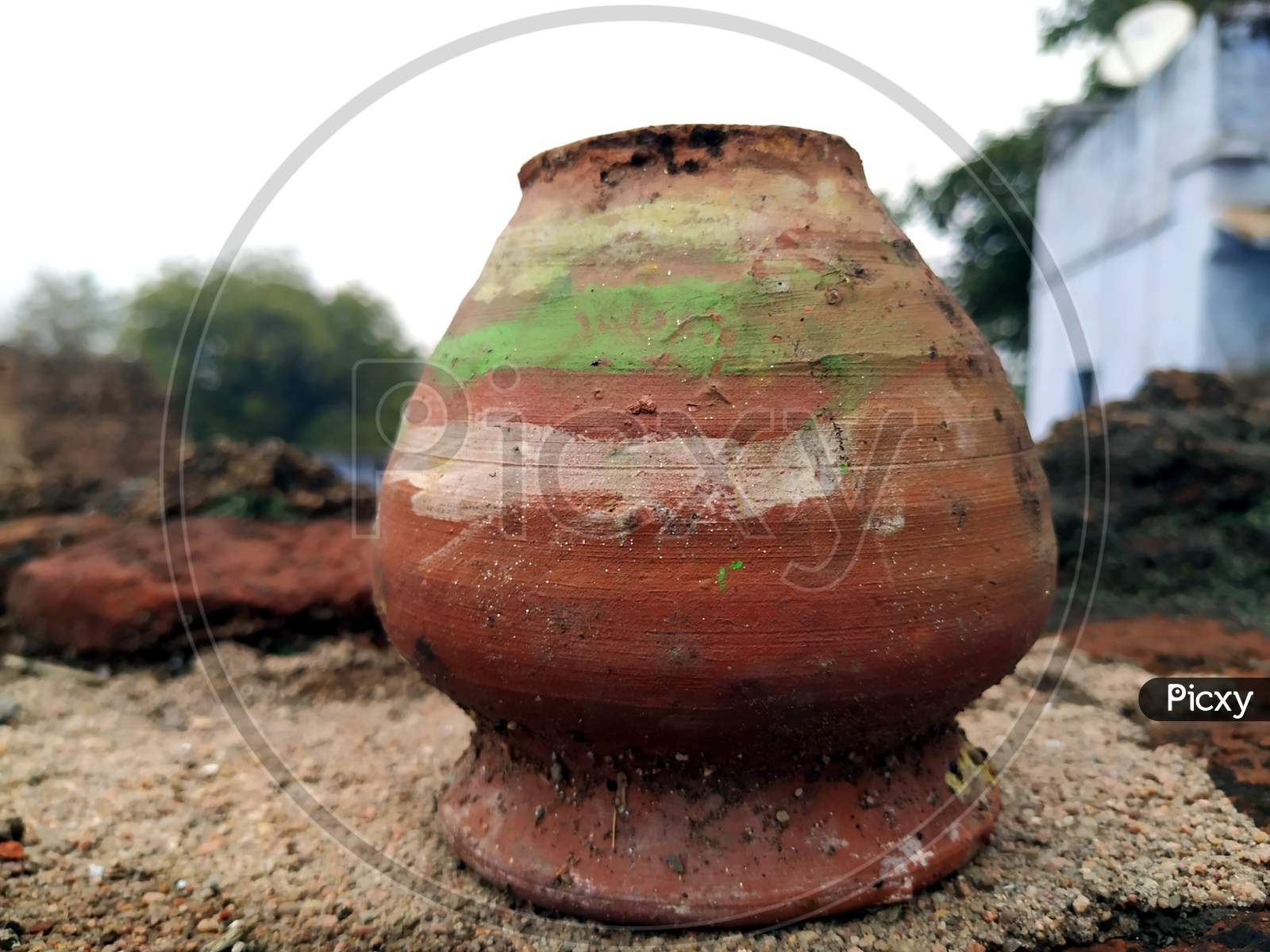a red clay pot put on muddy place