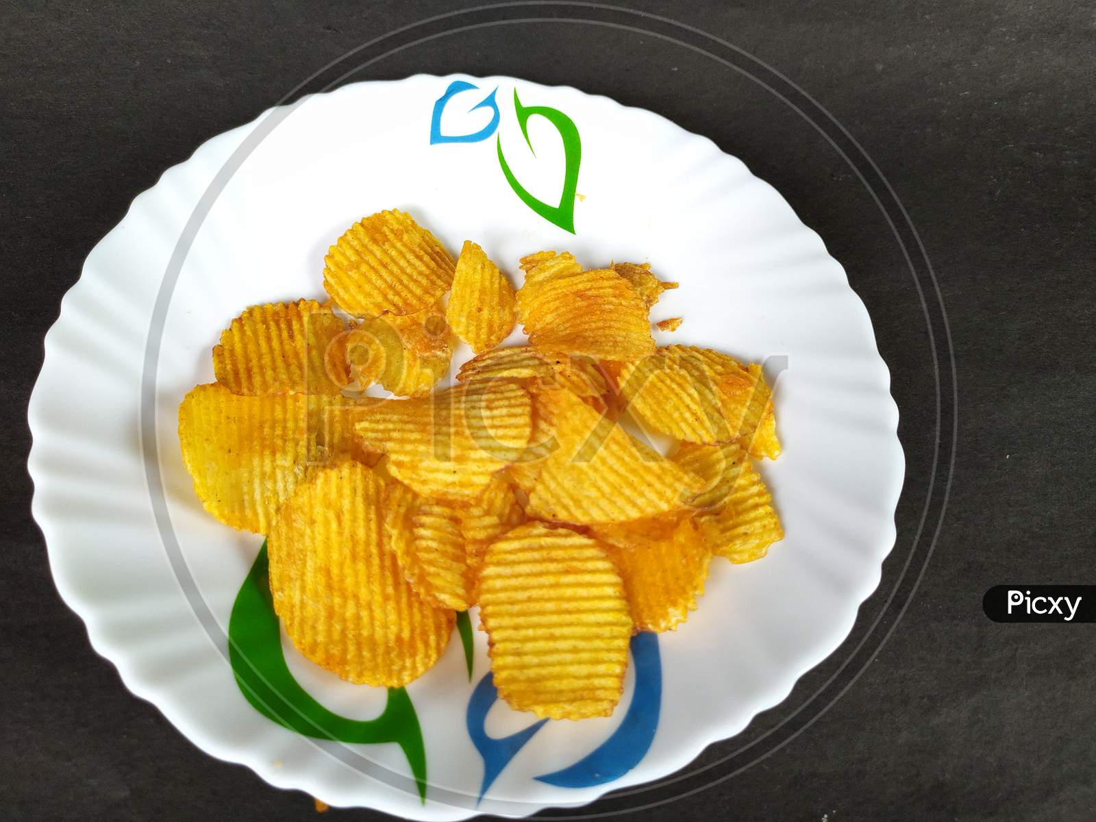 Tasty chips on plate.