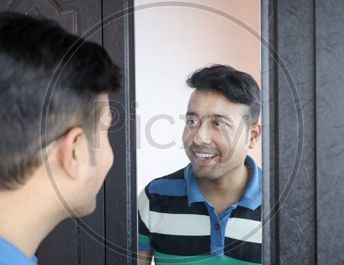 A Man Looking At His Reflection In Mirror Smiling In Happy Mood