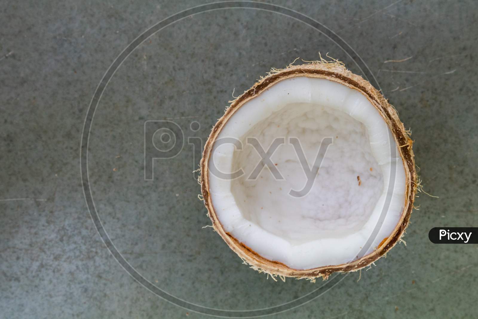 Top View Of A Half Cut Coconut On Plain Background
