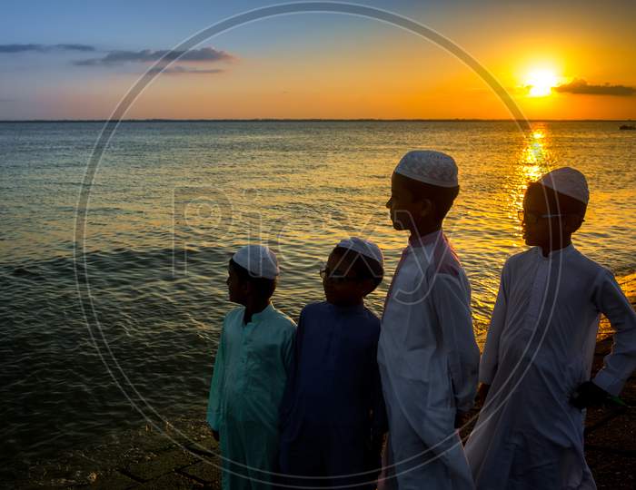 Bangladesh – June 22, 2019: Some Muslim Boys Are Standing By The Riverside Watching The Evening Sunset At Chandpur, Bangladesh.