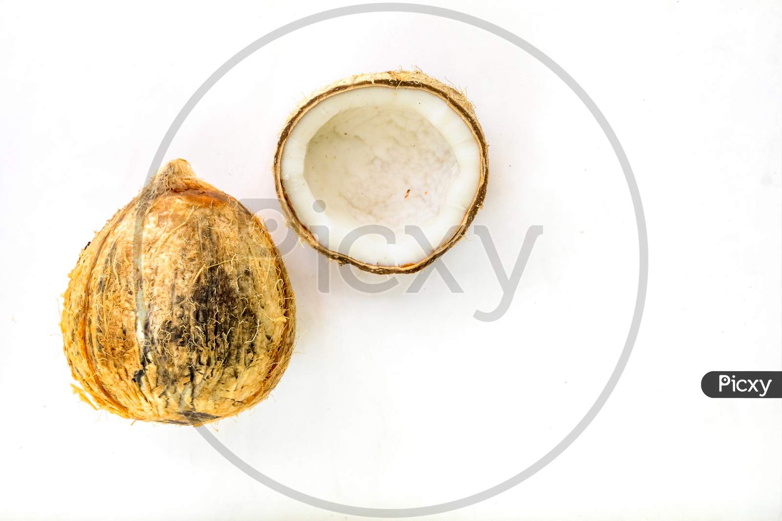 A Pealed And Cracked Coconut On Plain White Background