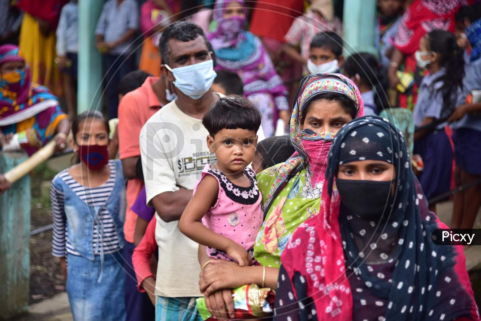 School Children With their families Stand In Queue For Free Rice And Money To Be Given By The Volunteers During Nationwide Lockdown Amidst Coronavirus Or COVID-19 Pandemic in Nagaon on May 14 2020