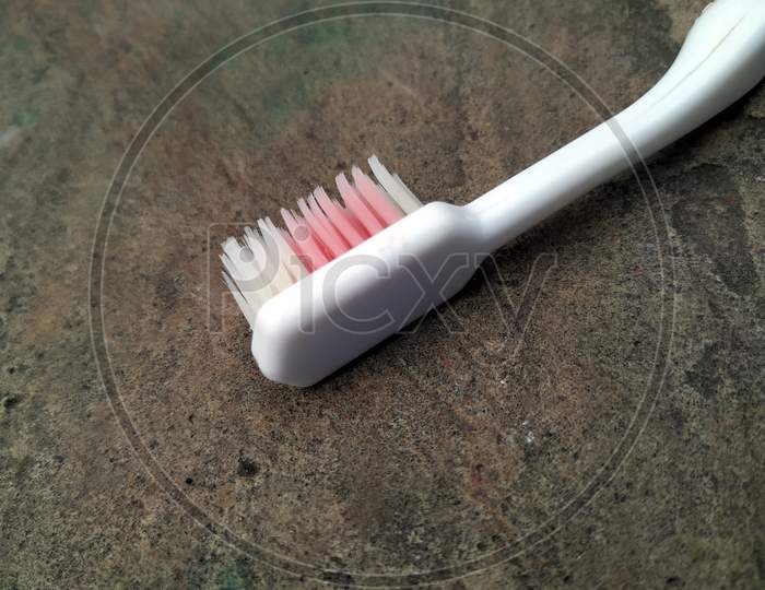 a white tooth brush put on a stone background