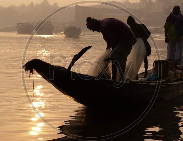 fishermen fishing on a boat early winter morning ( sunrise) in India