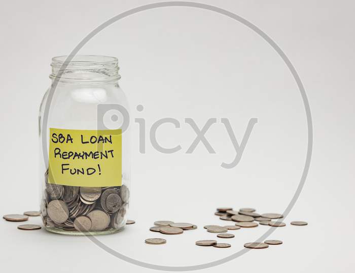 Savings For Loan Repayment With Coins Over an isolated White Background 