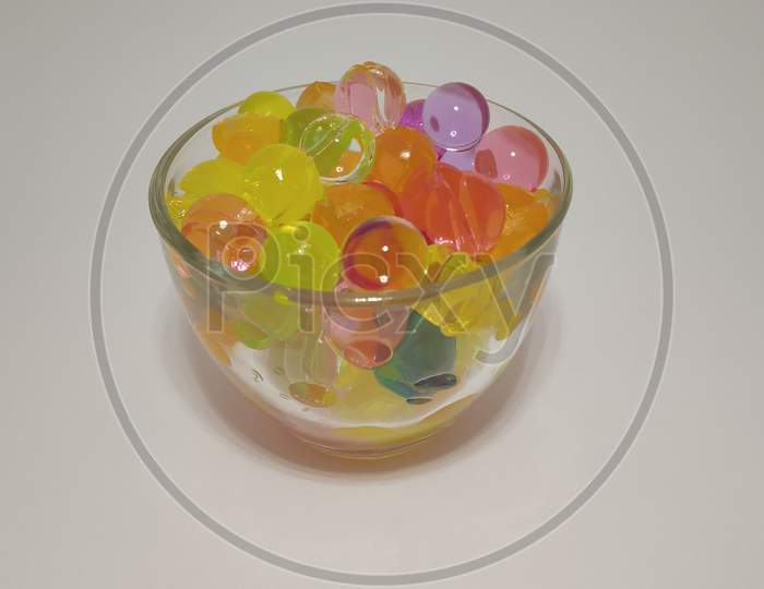 Multi colored round transparent sugar candies in glass