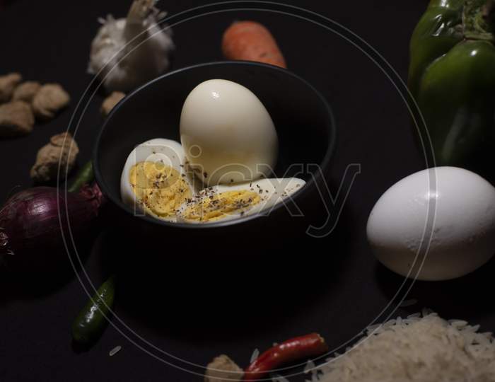 Boiled Eggs In A Bowl Decorated With Cereals And Vegetables In Dark Copy Space Background. Food And Product Photography.