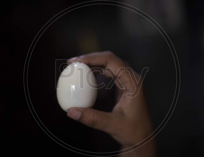 Woman Showing A Boiled Egg In The Kitchen. Indian Food And Breakfast.