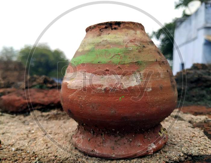 a red clay pot put on muddy place