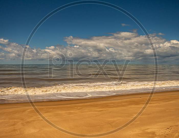Calm Sea On The Coast. Small Waves On The Shore. Huge Storm Cloud Over The Sea. Free Space.