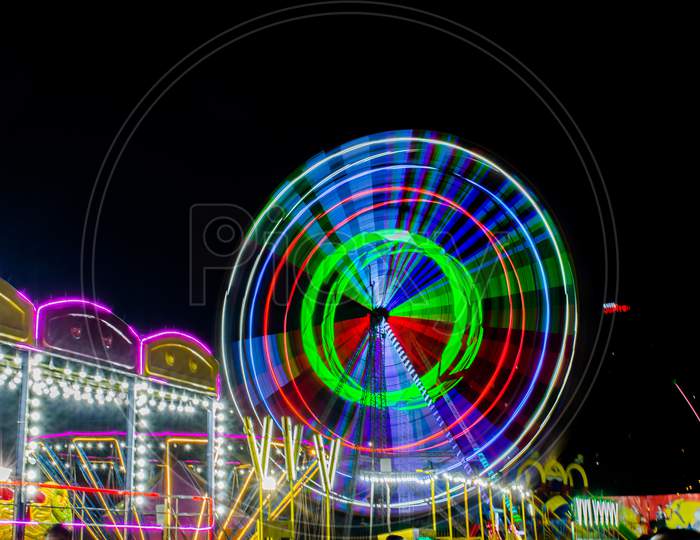 Night View of Amusement park rides, Ferris Wheel in diwali fair