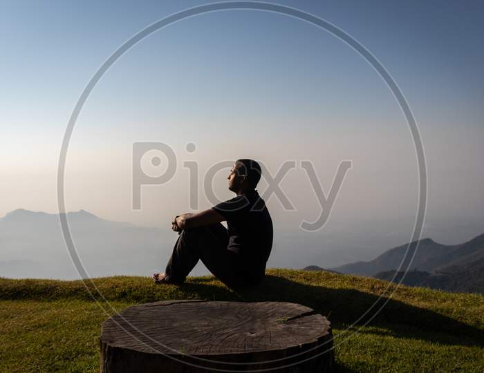 Man Isolated Watching Sunrise From Hill Top