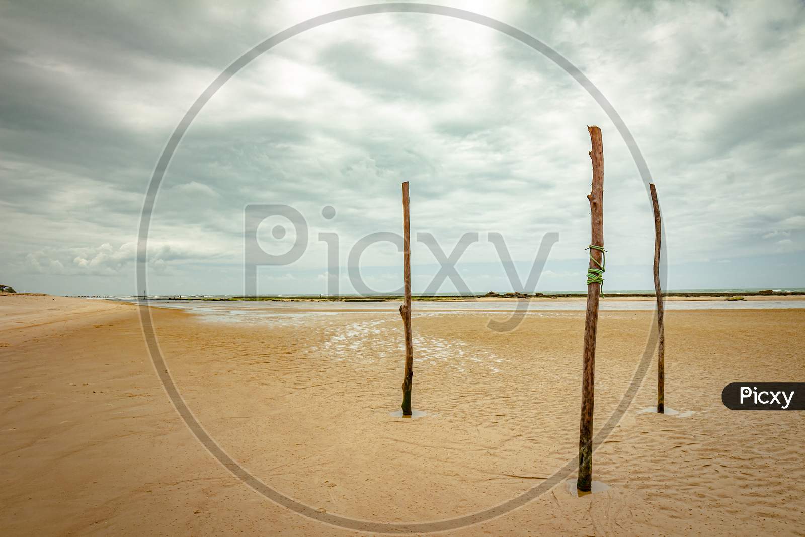 Three Wooden Poles On The Beach. Fine Art Photography. Desolate And Quiet Landscape.