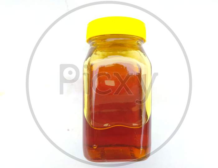 yellow color glass bottle in honey put in the bottle isolated on white background