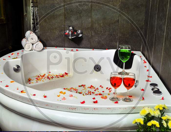 Bath tub with Flower and Drinks on corner