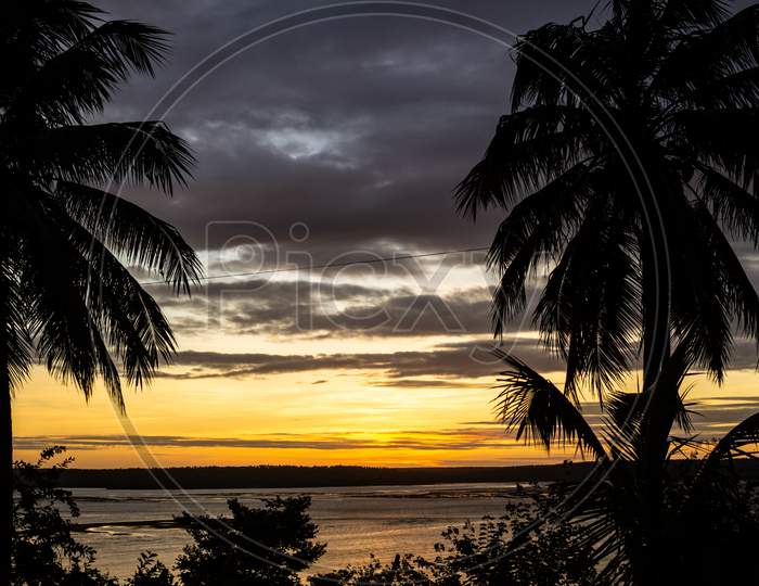 Beautiful Sunset In Tibau Do Sul. The Sun Sets Behind The Hills Reflecting Golden Light On The Lake.