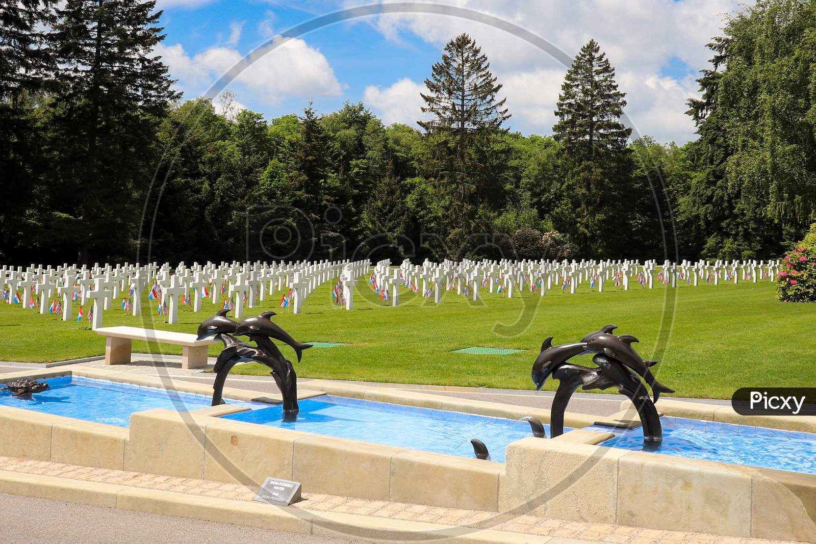 Dolphin Fountain At A Military Cemetery.