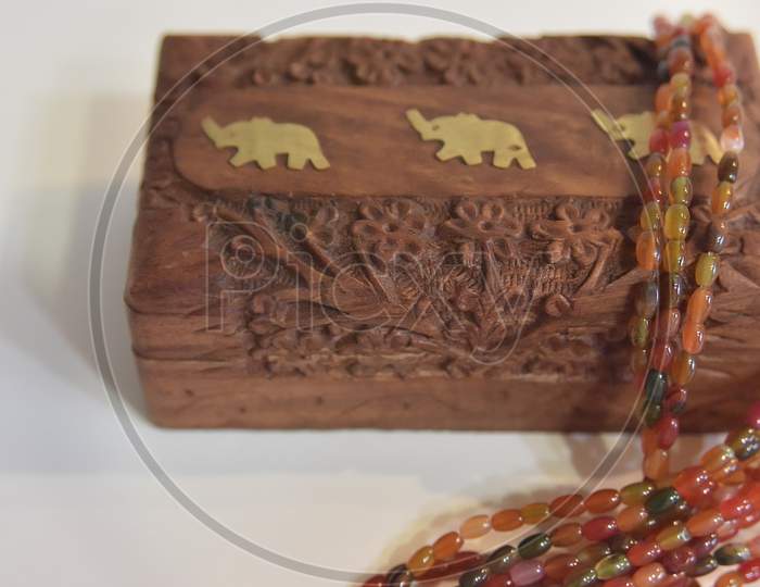 Carved Wooden Box And Tourmaline Beads. Selective Focus.