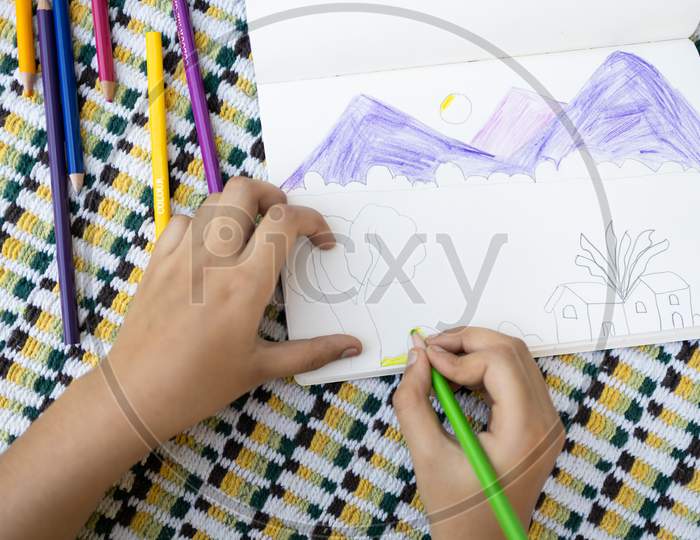 Top View Of Child Drawing A Scenery