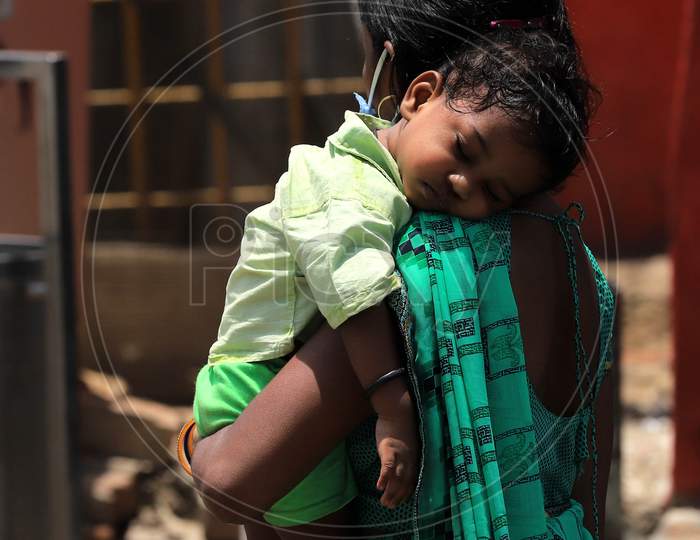 A Migrant Worker With Her Child Waiting to Board Bus To her Native Place During Extended Nationwide Lockdown Amidst Coronavirus Or COVID-19 Pandemic in Prayagraj