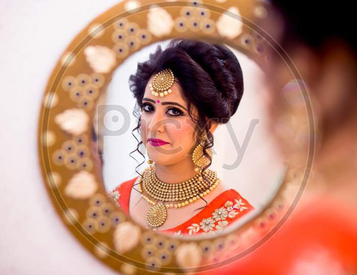 indian woman in traditional costume getting ready in front of mirror