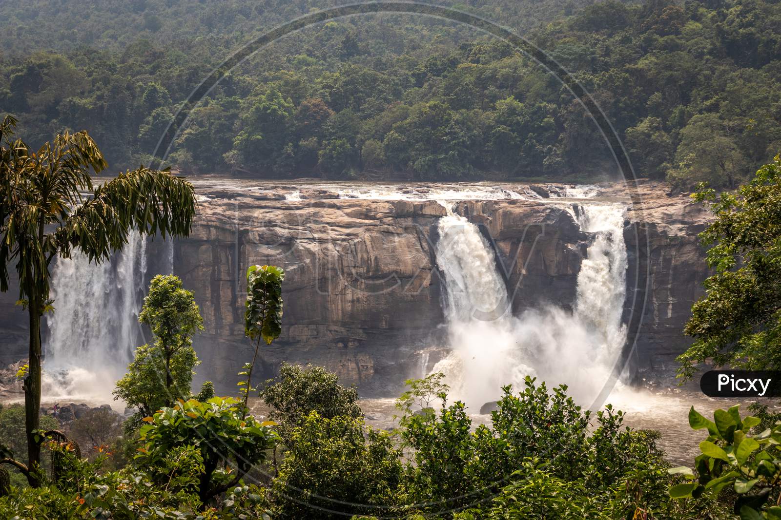 Waterfall Athirapally with blue sky and green forests of the western ghat range