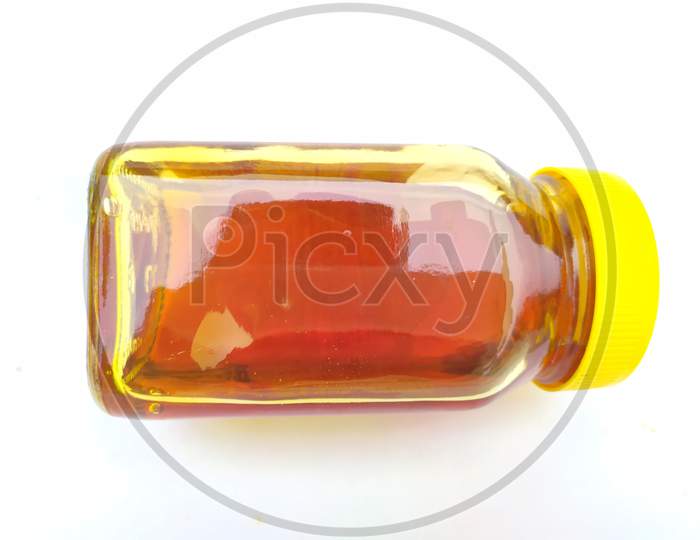 yellow color glass bottle in honey put in the bottle isolated on white background