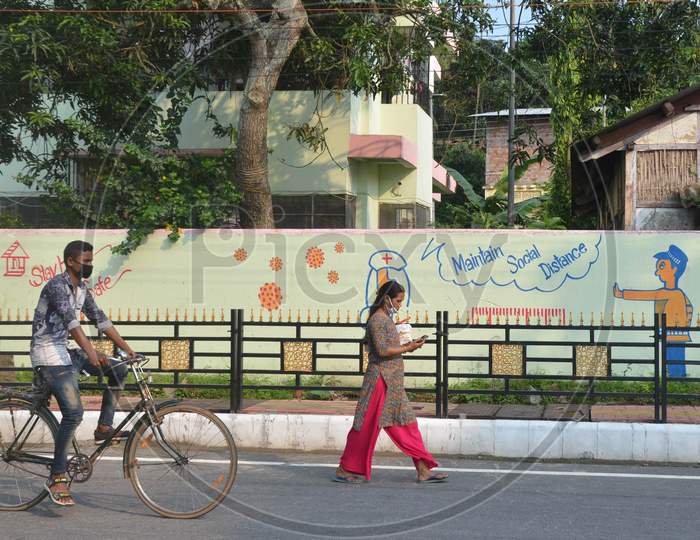 People Walk Past A Mural During Nationwide Lockdown Amidst Coronavirus or COVID-19 Pandemic  In Guwahati District Of Assam,India