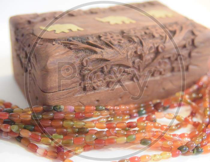 Carved Wooden Box And Tourmaline Beads. Selective Focus.