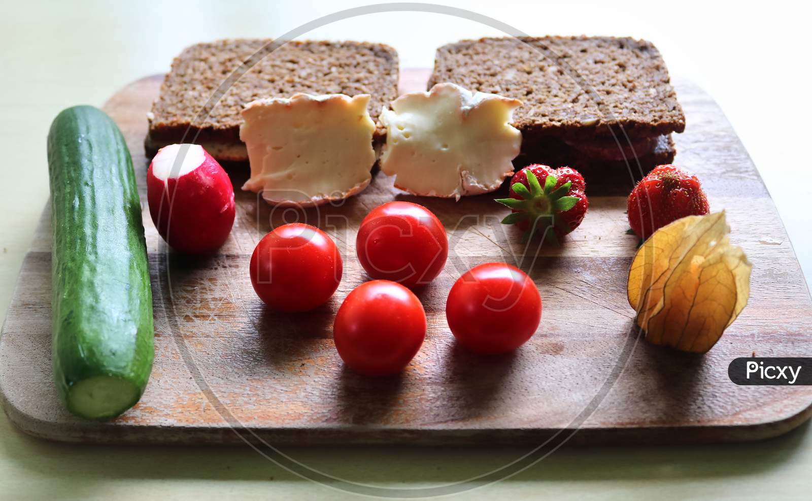 Close view on a healthy german breakfast with sandwiches tomatoes cucumbers and strawberries