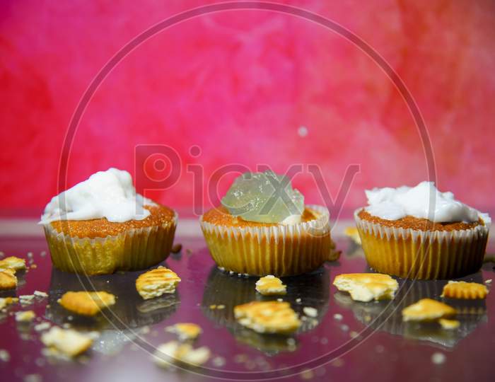 Fresh tasty cupcake on dark background.Beautiful delicious red velvet capkake with a creamy cream cap on a shale stone stand against a black background