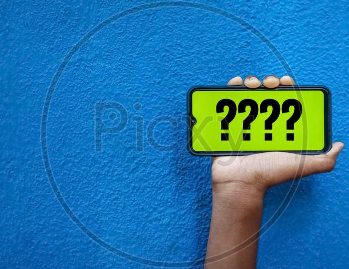 Question Mark Wording On Smart Phone Screen Isolated On Blue Background With Copy Space For Text. Person Holding Mobile On His Hand And Showing Front Of The Screen Symbol ? Question Mark
